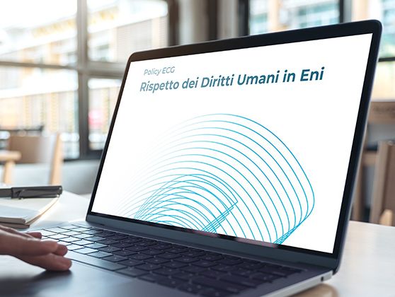  In a room, a hand moves across a laptop, and the screen reads: “ECG Policy, Respect for Human Rights at Eni” in Italian.