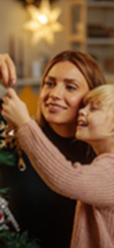 Mamma e figlia decorano l'albero di Natale di casa