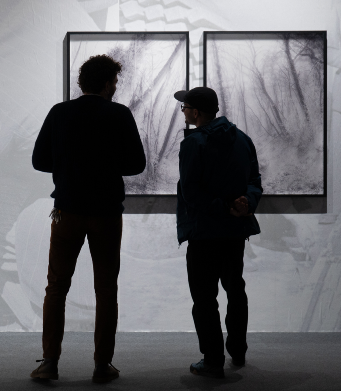 due ragazzi che guardano i quadri della mostra