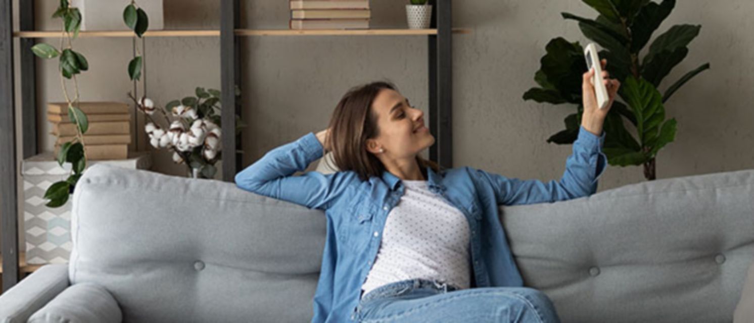 Mujer regulando la temperatura del aire acondicionado