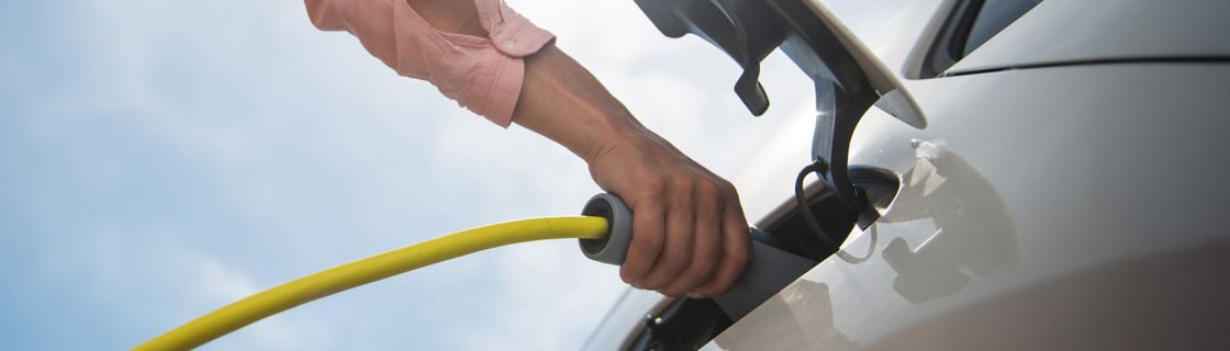 Persona che ricarica auto elettrica