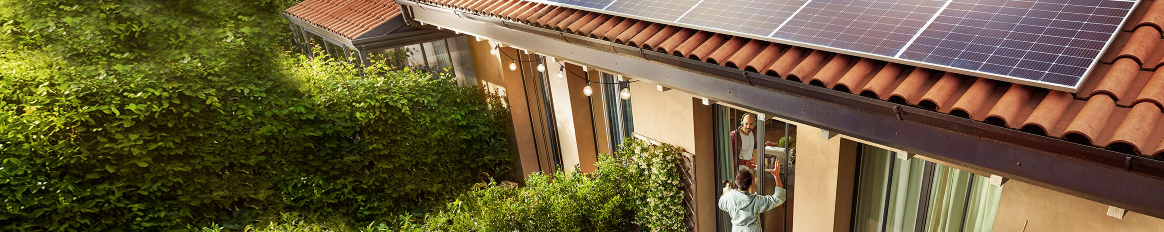 Casal numa casa com painéis solares no telhado