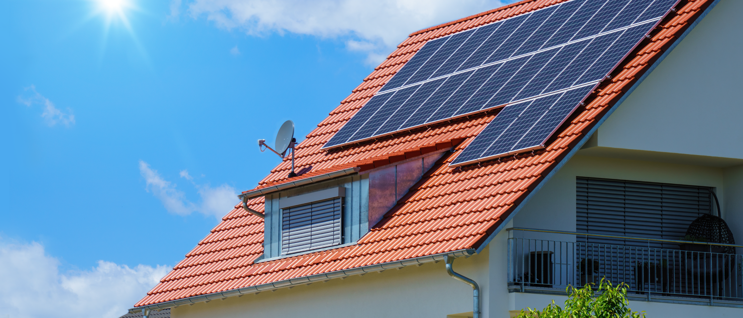 Imagen de una casa con placas solares instaladas en un día soleado