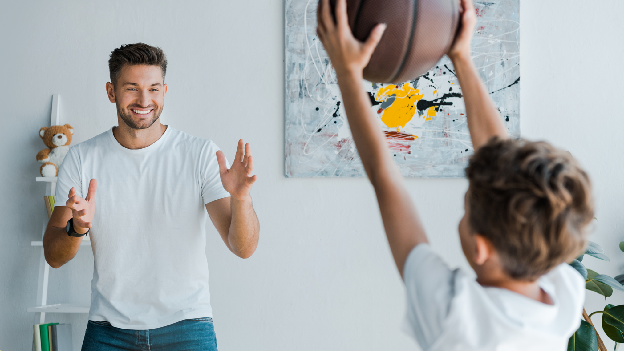 Padre e hijo jugando con pelota en casa