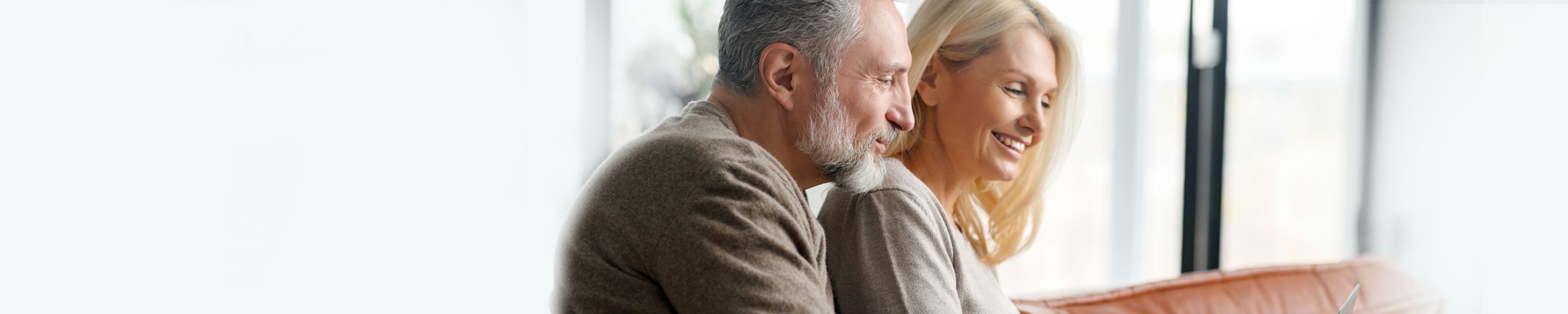 Pareja de mediana edad sentados cómodos en sofá