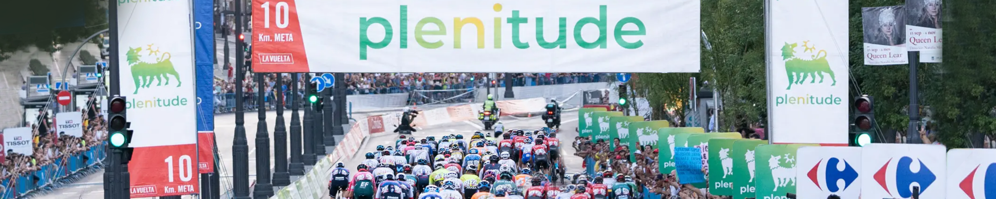 Pelotón ciclista La Vuelta con carteles patrocinio Plenitude