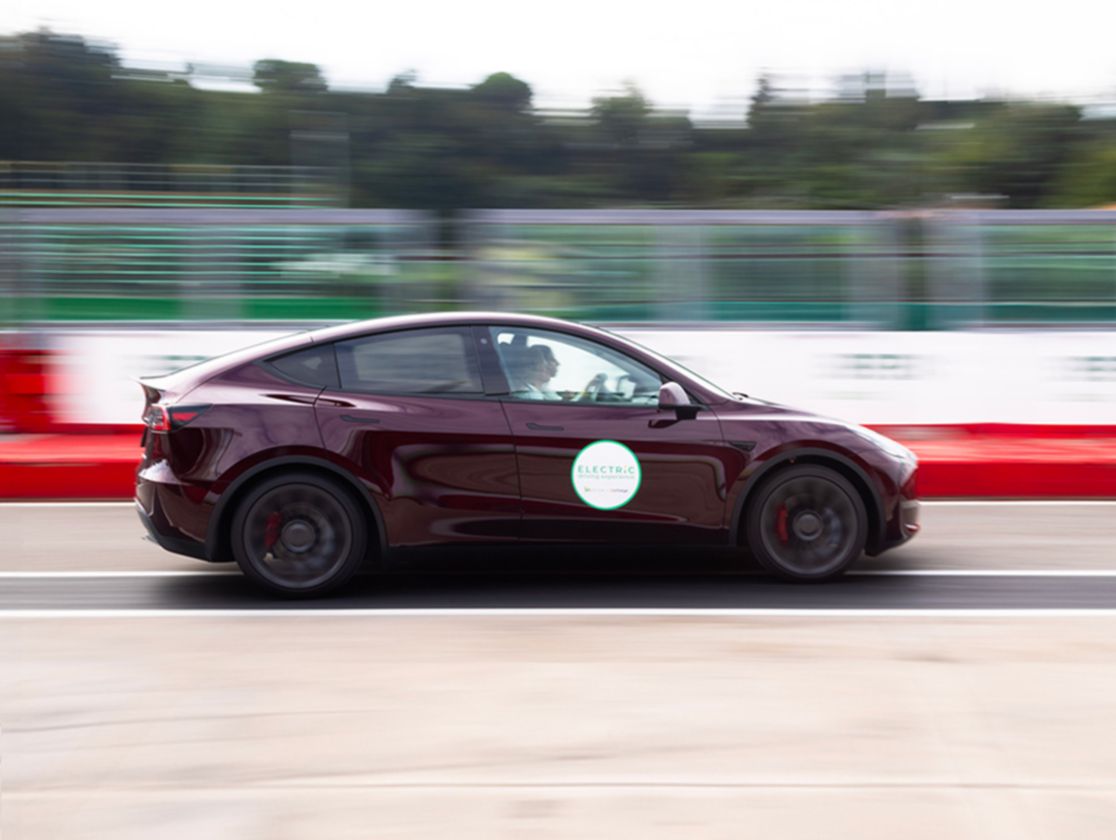 Un'auto elettrica bordaux sfreccia in pista, sul lato c'è un grande adesivo con scritto Electric e i loghi di Plenitude e BeCharge.