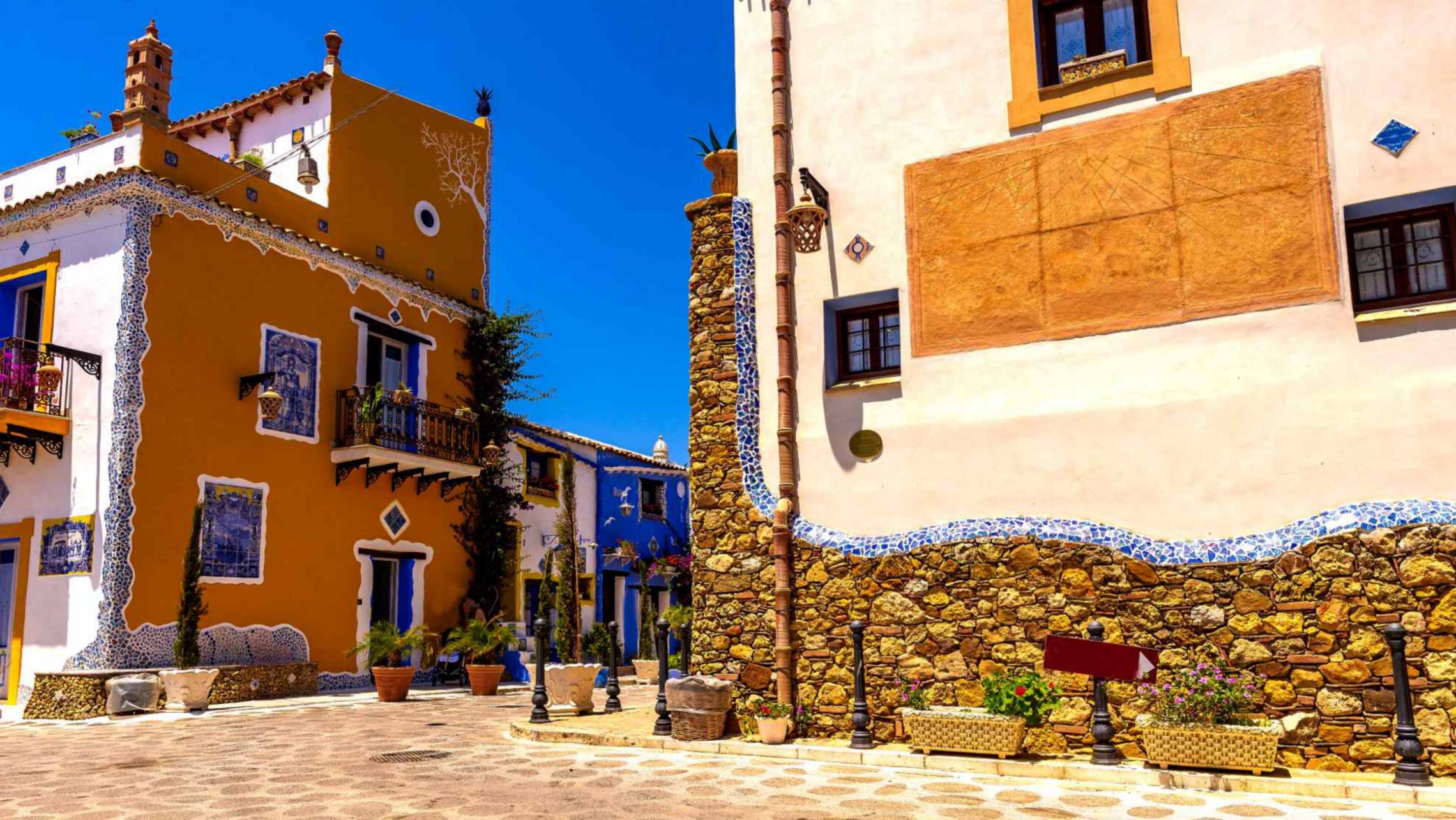Piazza colorata del villaggio mediterraneo sotto la luce del sole 