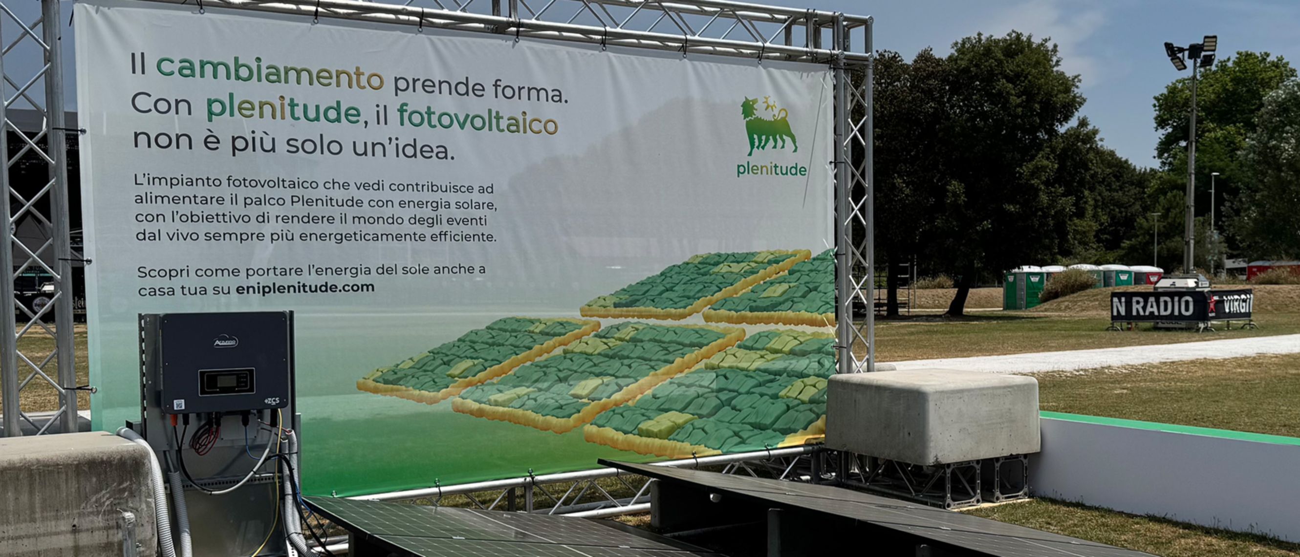 Esposizione di pannelli solari con uno striscione Plenitude