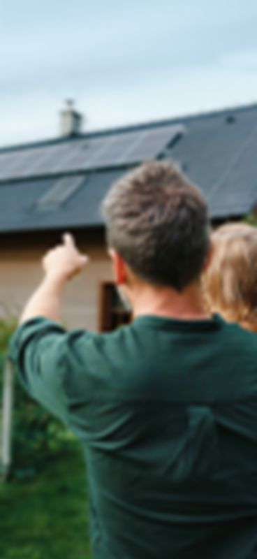 Un uomo e una bambina con un pannello fotovoltaico sullo sfondo