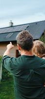 Un uomo e una bambina con un pannello fotovoltaico sullo sfondo