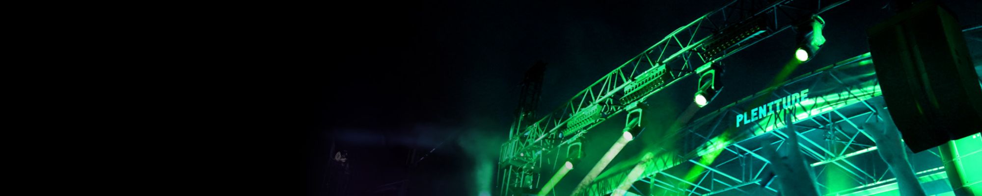 Una multitud escucha música frente a un escenario.