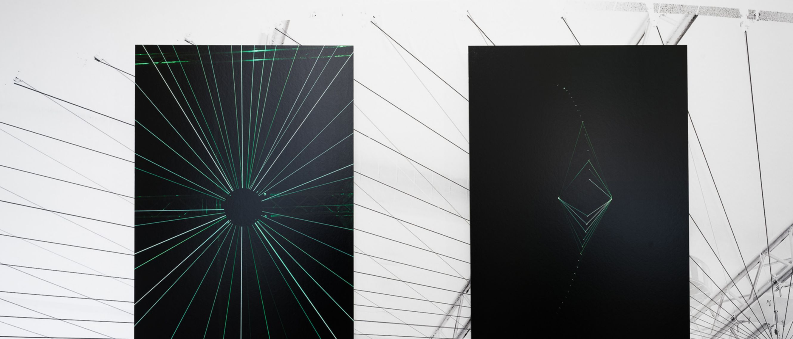 Two of the paintings exhibited at CAMERA, both featuring a black background and green light details