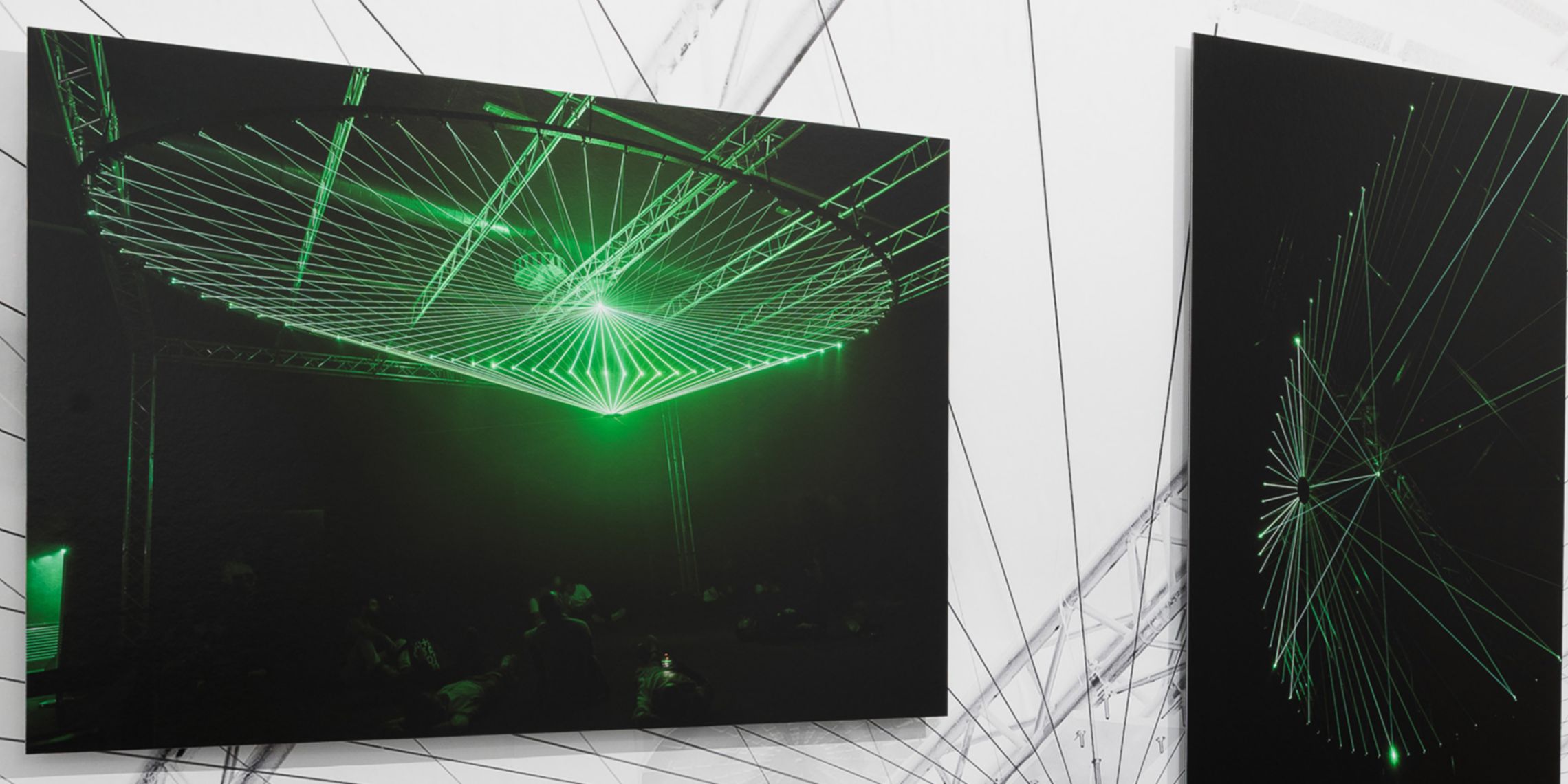 Two of the paintings exhibited at CAMERA, both featuring a black background and green light details