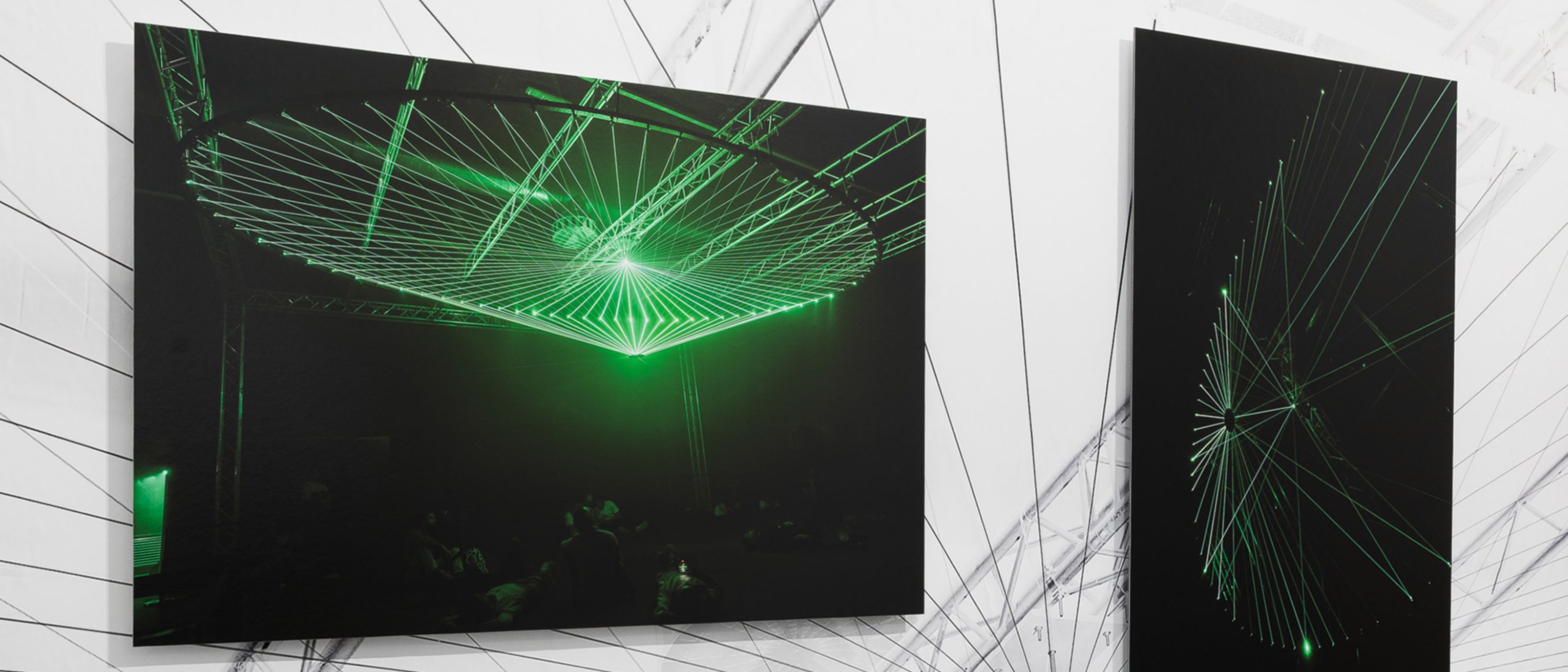 Two of the paintings exhibited at CAMERA, both featuring a black background and green light details