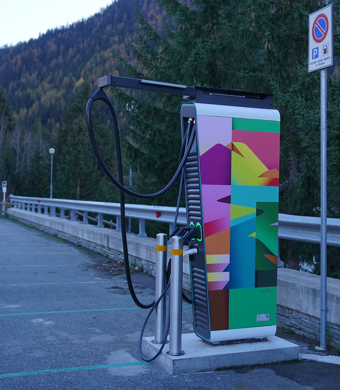 On one street is an electric vehicle charging station decorated with one of the works from Plenitude's “Art in motion” project.