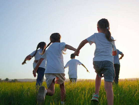 Bambini che corrono in un prato