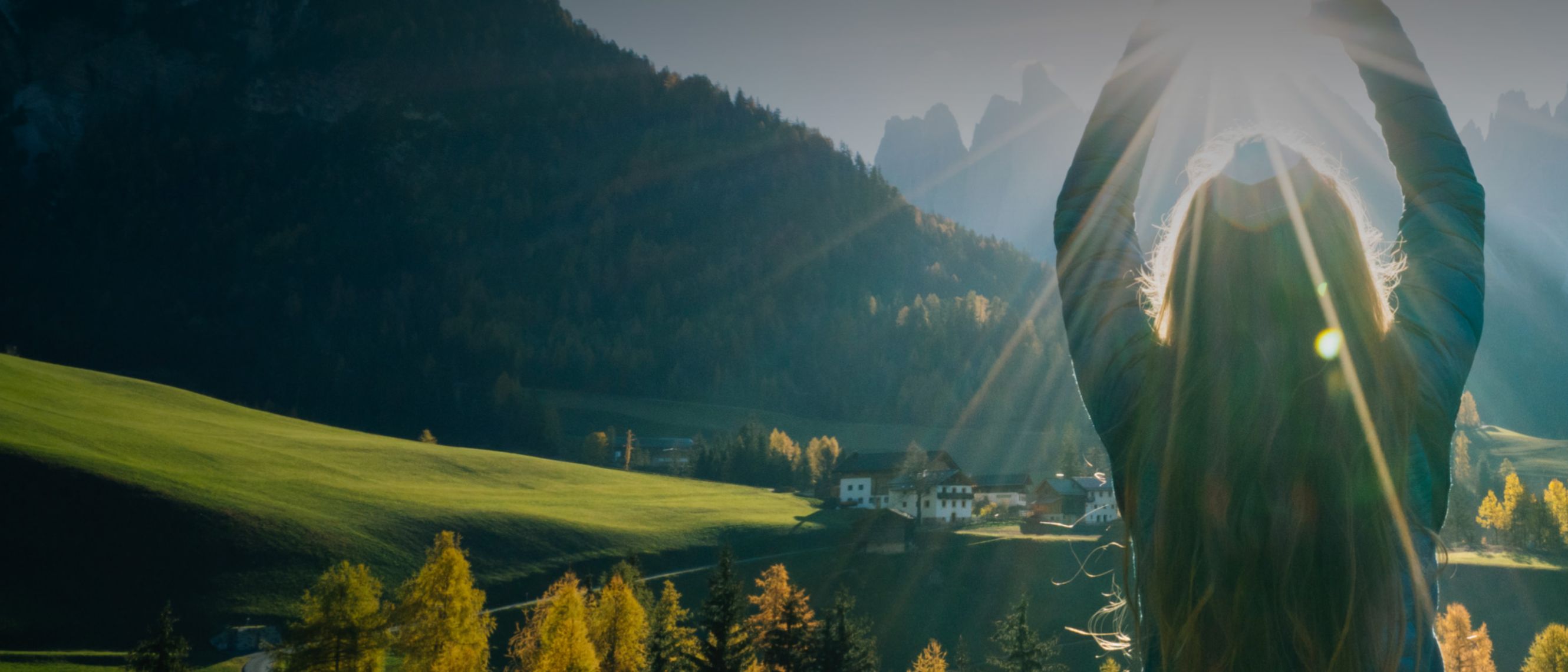 A person from behind observing a stunning mountain landscape