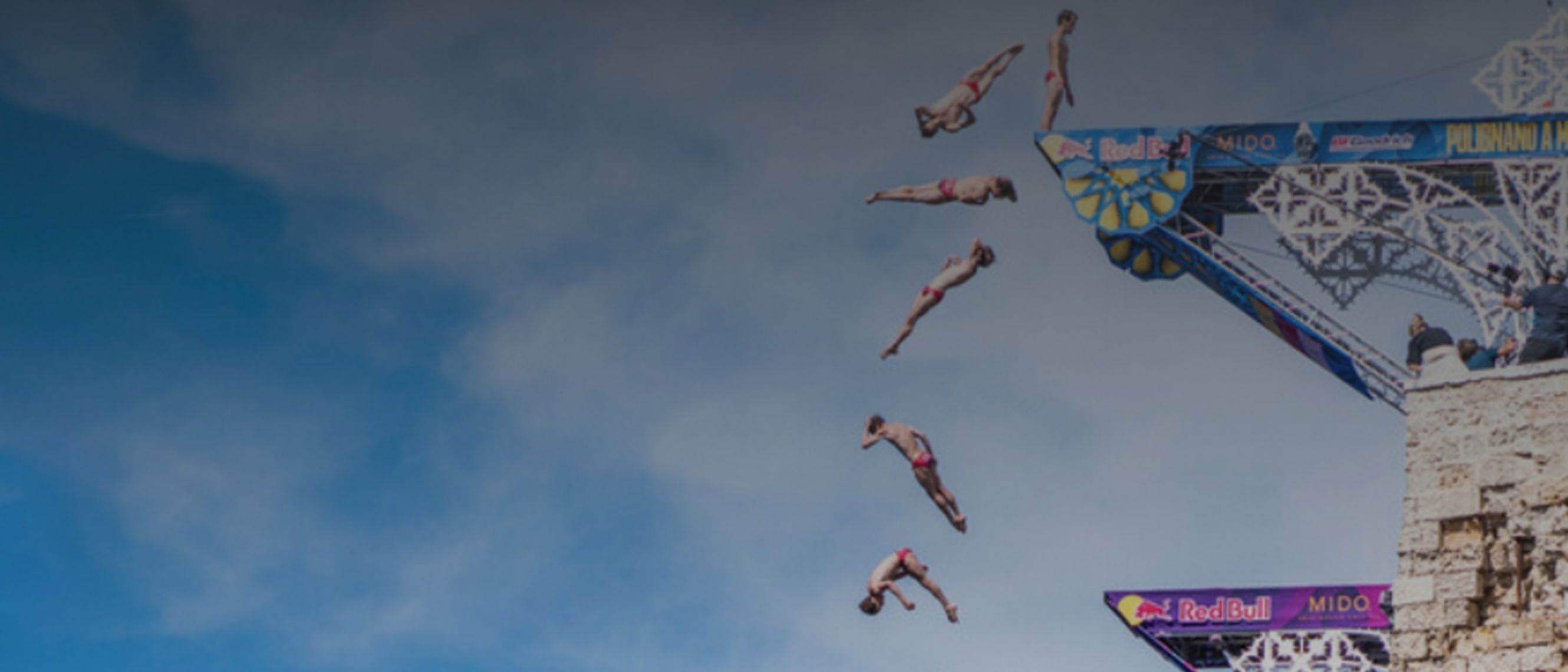 A diver dives off the Red Bull branded diving board and we see in the picture the various stages of his jump.