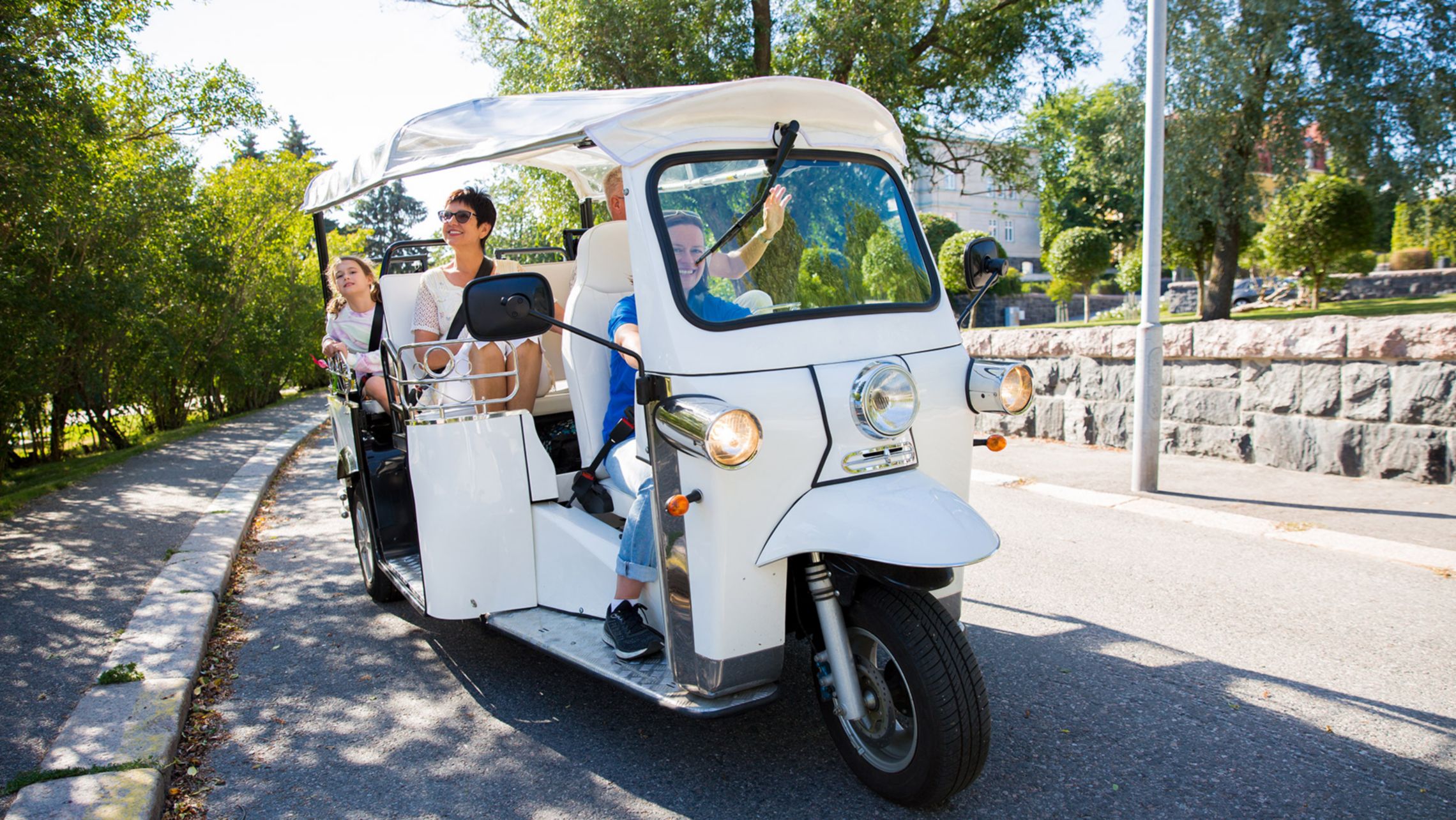 Un gruppo di turisti attraversa il centro città in un tuk-tuk elettrico