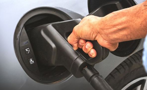 Uomo che ricarica un'auto elettrica